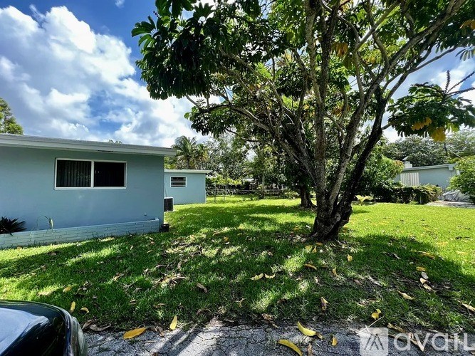 A white house with a tree in front of it.