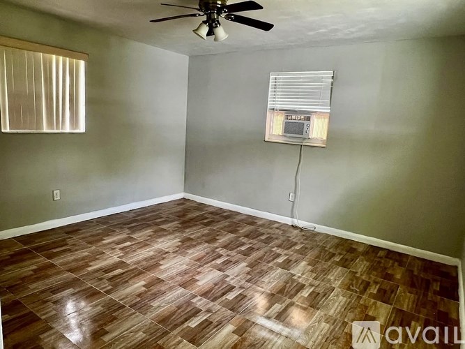 A room with a ceiling fan and wooden flooring.