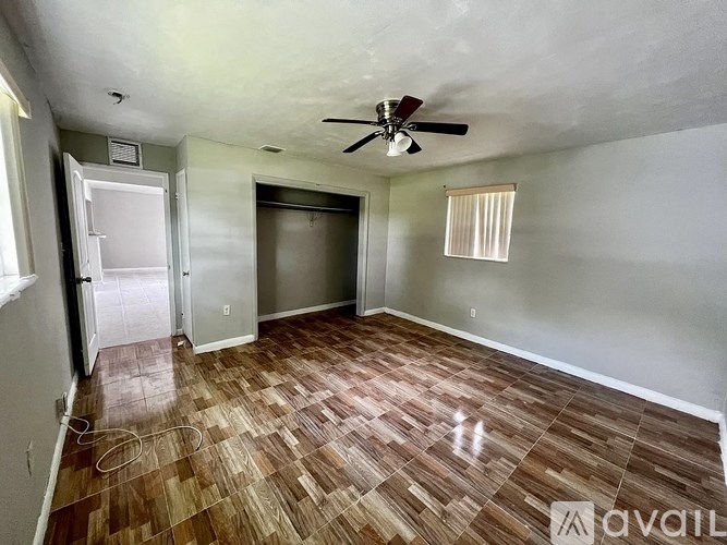 A room with a ceiling fan and wooden flooring.