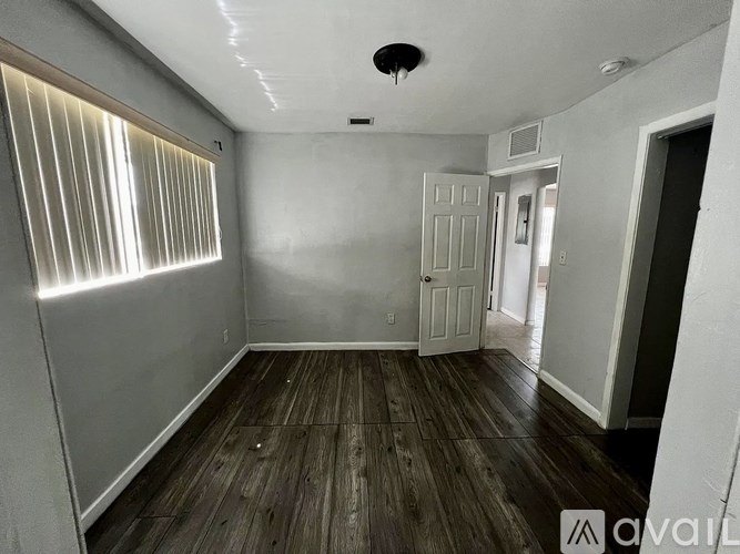 A room with wooden floors and a white door.