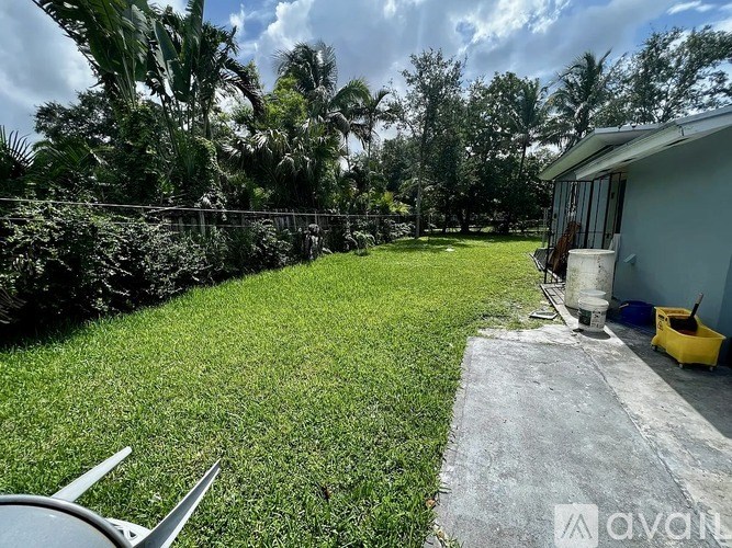 A backyard with a well-maintained lawn and a house in the background.