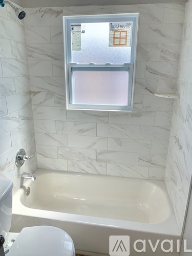 A bathroom with a white tub and toilet.