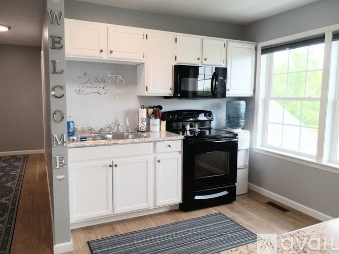 A kitchen with a black stove top oven and white cabinets.
