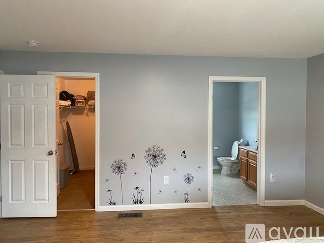 A room with a white door and a wall with dandelion wall decals.