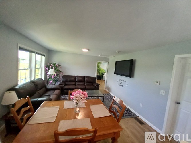 A dining room with a wooden table set for two.