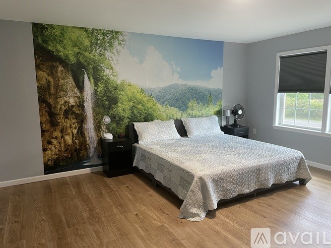 A bedroom with a large mural of a waterfall on the wall.