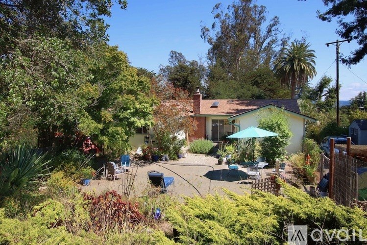 A house with a green lawn and trees surrounding it.