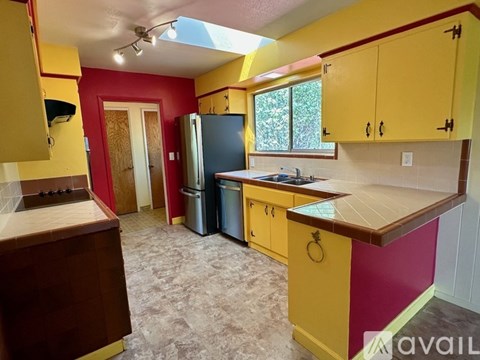A kitchen with yellow cabinets and a blue refrigerator.