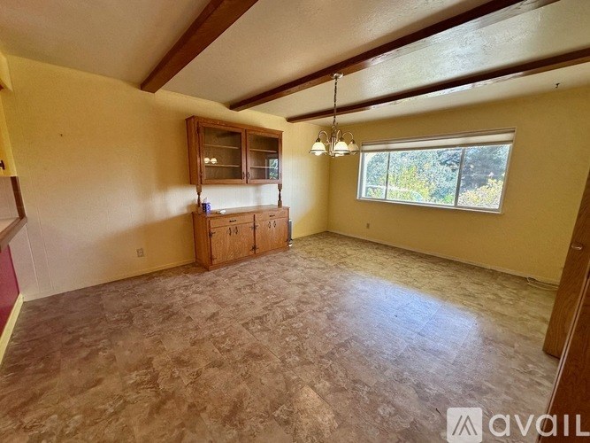 A room with a wooden cabinet and a window.