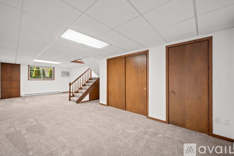 A room with a staircase and three doors.