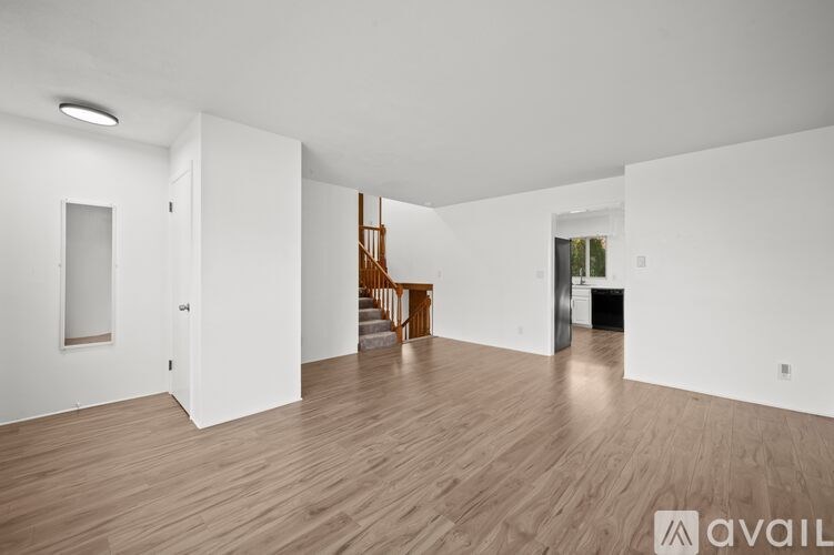 A room with wooden floors and a staircase.