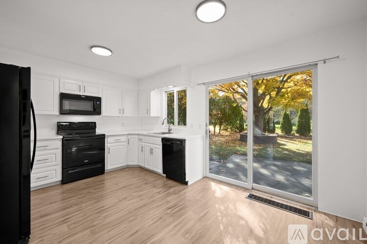 A kitchen with black appliances and white cabinets.