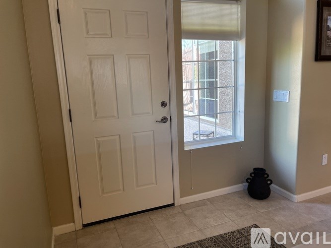 A white door with a black handle is in a room with a window.