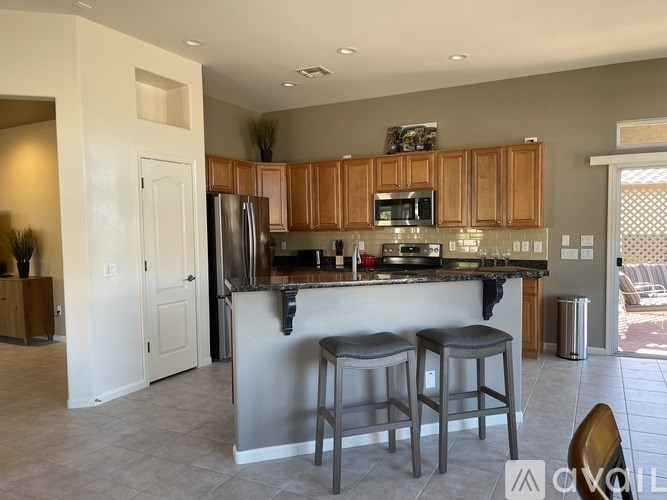 A kitchen with a bar stool and a counter.