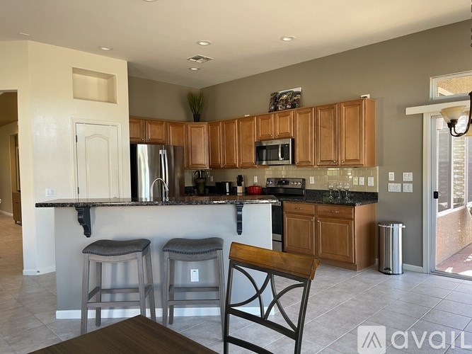 A kitchen with wooden cabinets and a black countertop.