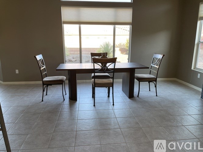 A dining room with a table and chairs.