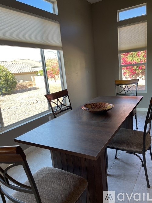 A dining room with a table and chairs.