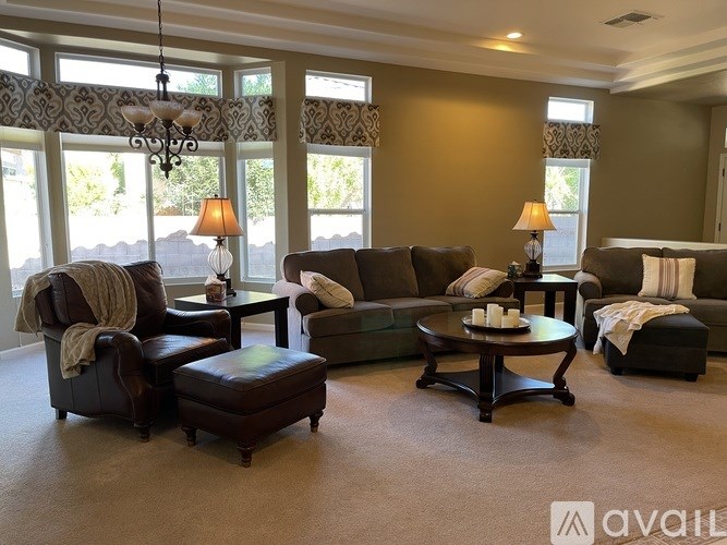 A living room with brown furniture and a large window.