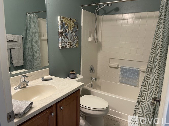 A bathroom with a white toilet, a sink, and a shower.