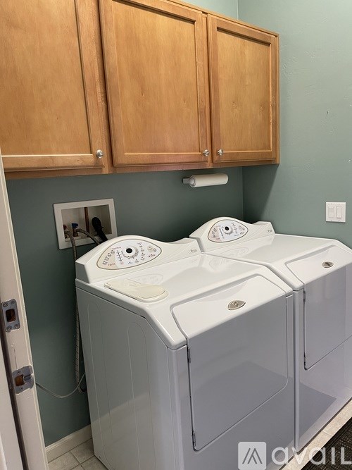 A white washing machine and dryer in a laundry room.