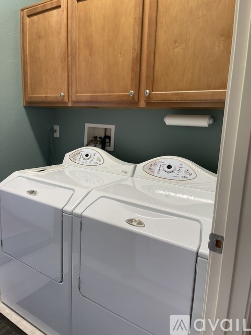 A white washing machine and dryer in a laundry room.