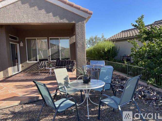 A patio with a table and chairs is set up outside a house.