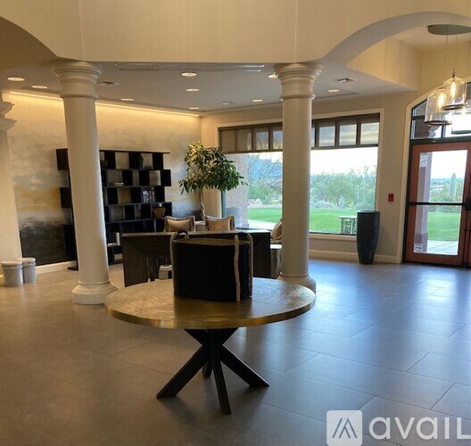 A large, open living room with a round table and a fireplace.
