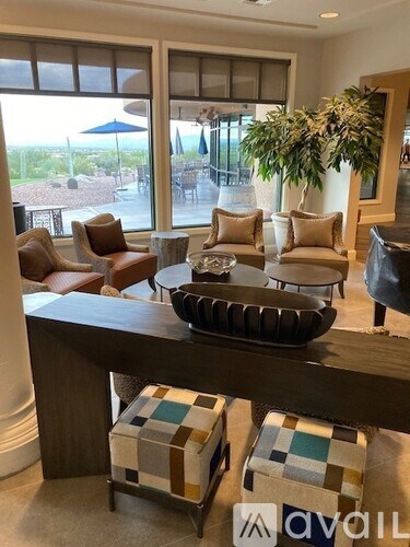 A living room with a brown sofa, a coffee table, and a large window.