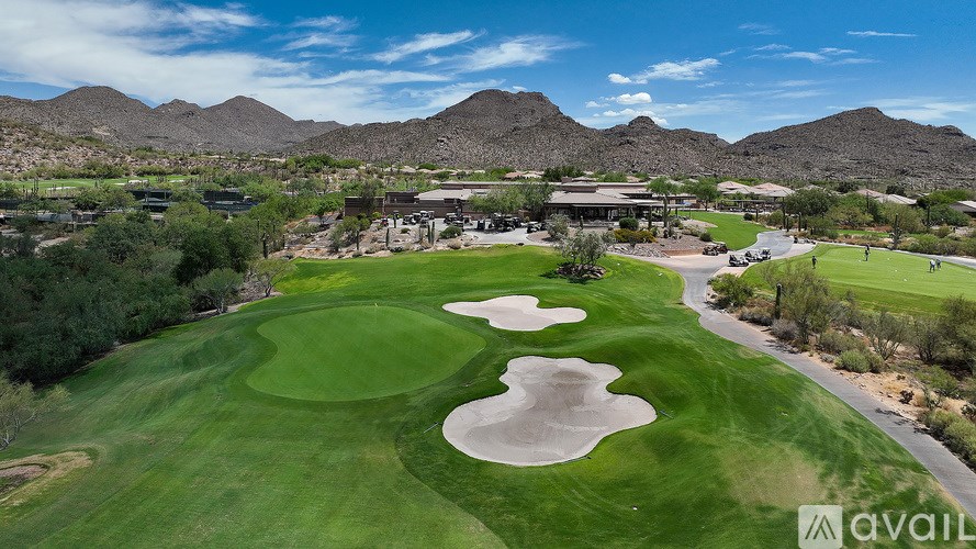 A golf course with a green and a sand trap.