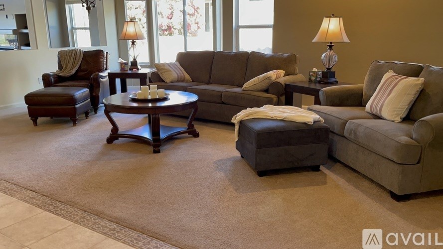 A living room with brown furniture and a rug.
