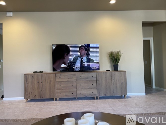 A living room with a television on a wooden cabinet.