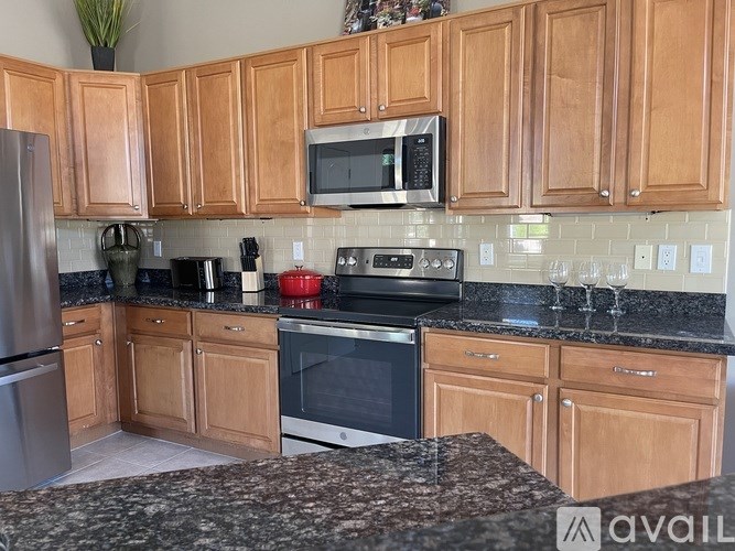 A kitchen with wooden cabinets and granite countertops.