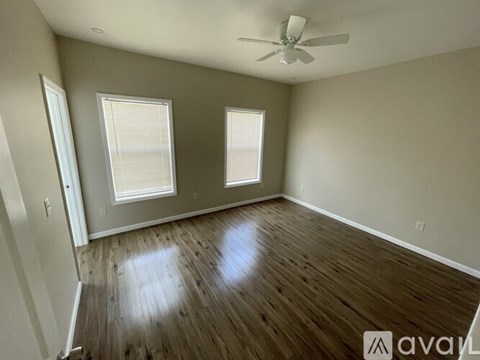 A room with wooden flooring and a ceiling fan.