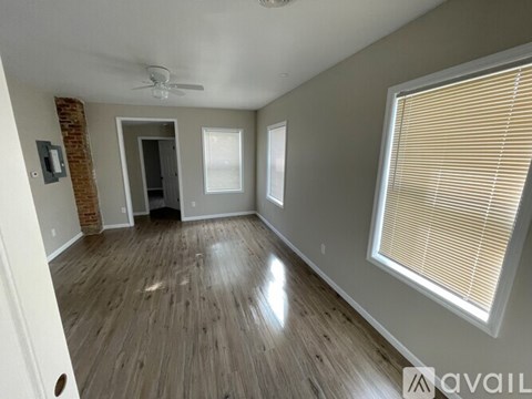 A room with wooden flooring and a ceiling fan.