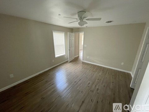 A room with wooden floors and a ceiling fan.