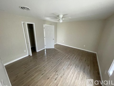 A room with a ceiling fan and two doors.