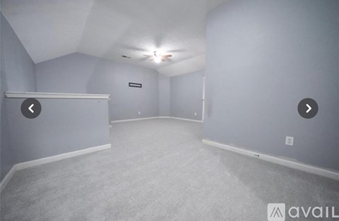 A spacious room with a carpeted floor and a white ceiling.