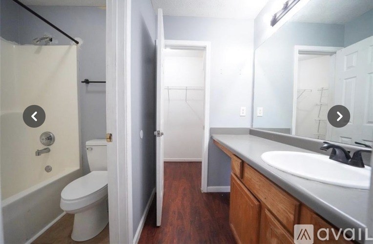A bathroom with a toilet, sink, and mirror.