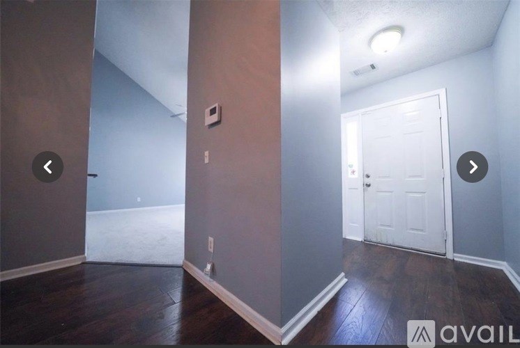 A hallway with a door on the right and a wall on the left.