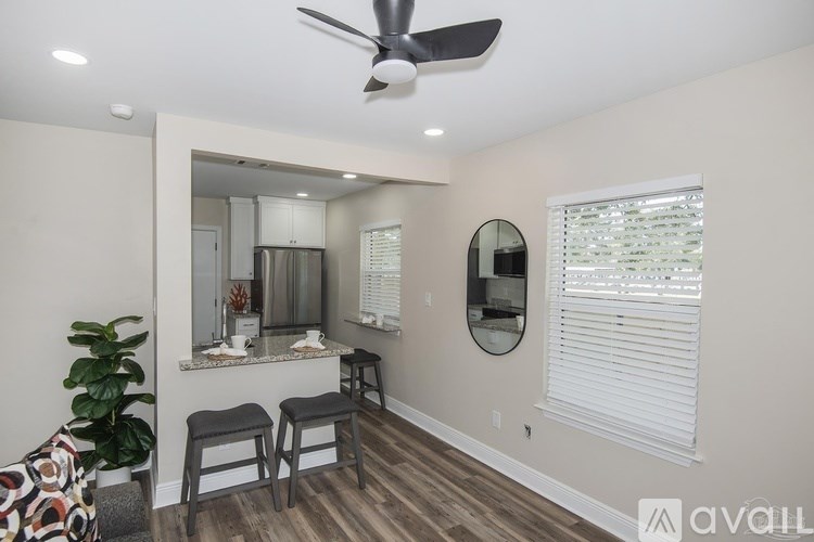 A room with a ceiling fan and a mirror on the wall.