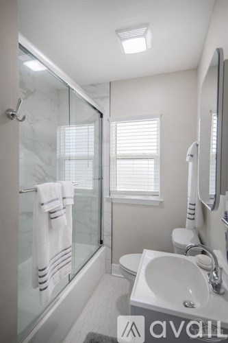 A white sink in a bathroom with a glass shower door.