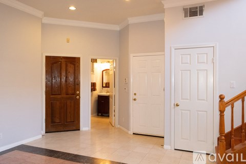 A hallway with a wooden door on the left and a white door on the right.