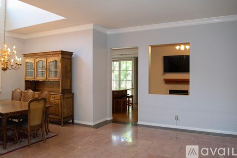A dining room with a wooden table and chairs.