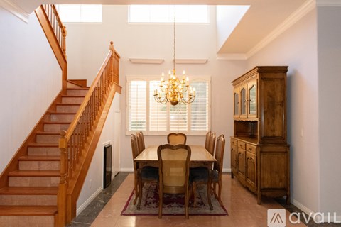 A dining room with a wooden table and chairs.