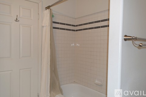 A white bathroom with a white tub and a white shower curtain.
