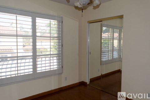 A room with a sliding glass door and a window with blinds.