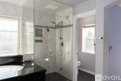 A bathroom with a marble sink and a walk-in shower.