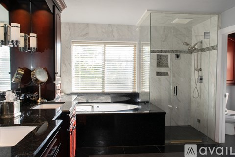 A modern bathroom with a large mirror and a walk-in shower.