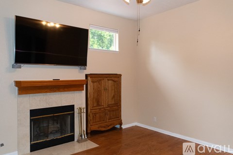 A living room with a fireplace and a flat screen TV mounted above it.