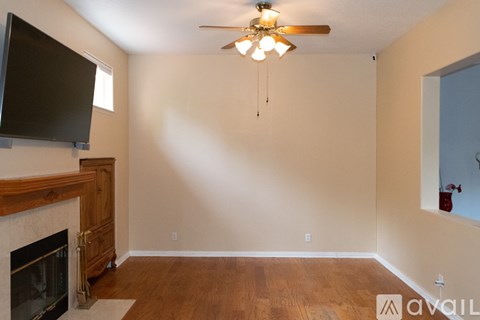 A living room with a fireplace and a flat screen TV mounted above it.